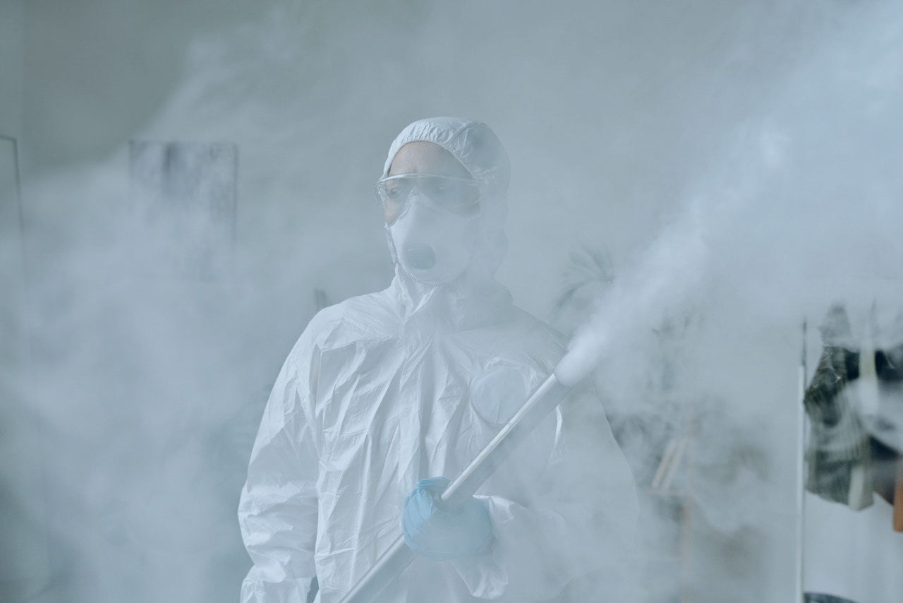 Woman in PPE holding a chemical spray device